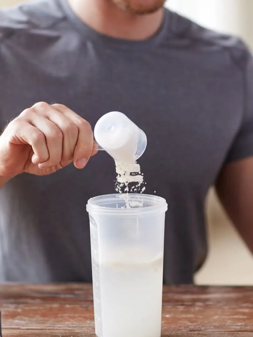 Pouring a single Surplus stick into a shaker bottle.